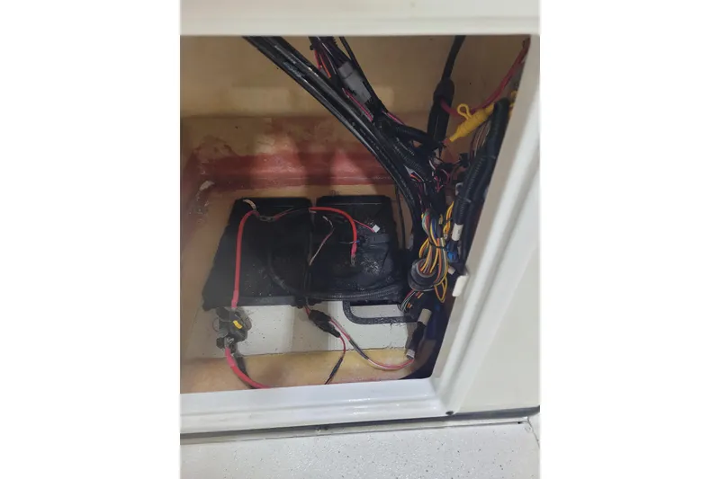 Slide: The Image of 2024 Ranger RB210 boat wiring and battery compartment with organized cables. - 14