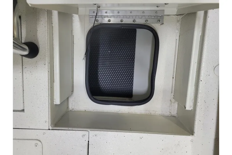 Slide: The Image of 2024 Ranger RB210 boat hatch with textured black mat and metal hinge. - 16