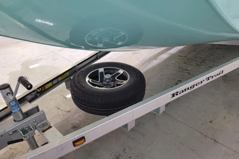 Slide: The Image of 2024 Ranger RB210 boat on trailer with spare tire underneath. - 2