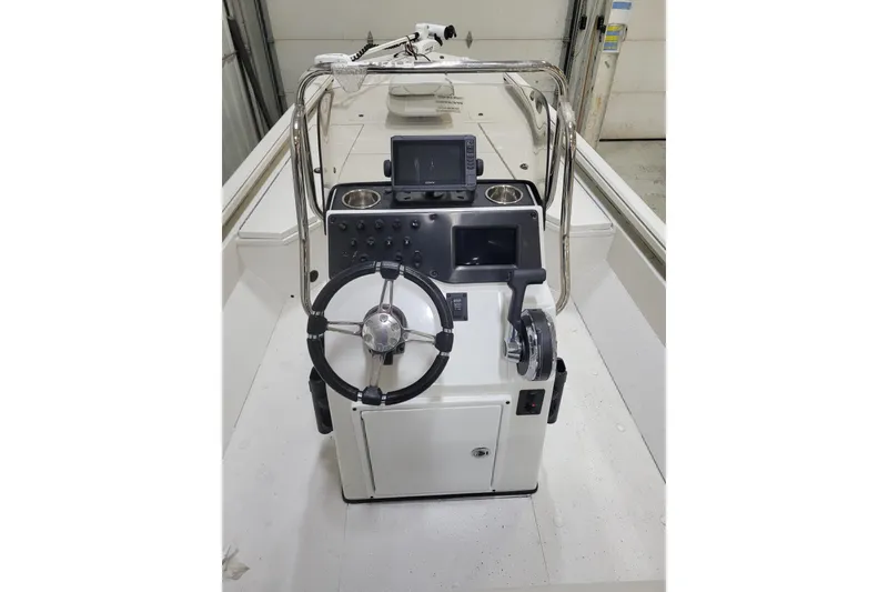 Slide: The Image of 2024 Ranger RB210 boat console with steering wheel and controls in a garage setting. - 20