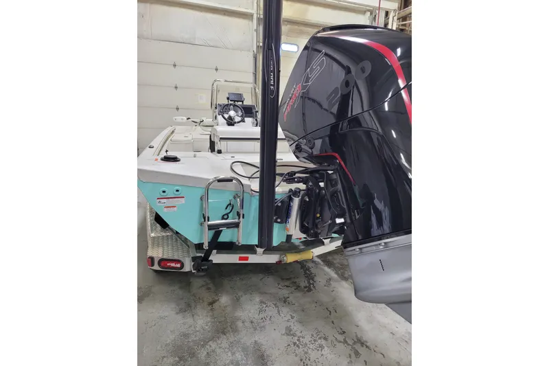 Slide: The Image of 2024 Ranger RB210 boat with powerful outboard motor in a garage setting. - 30