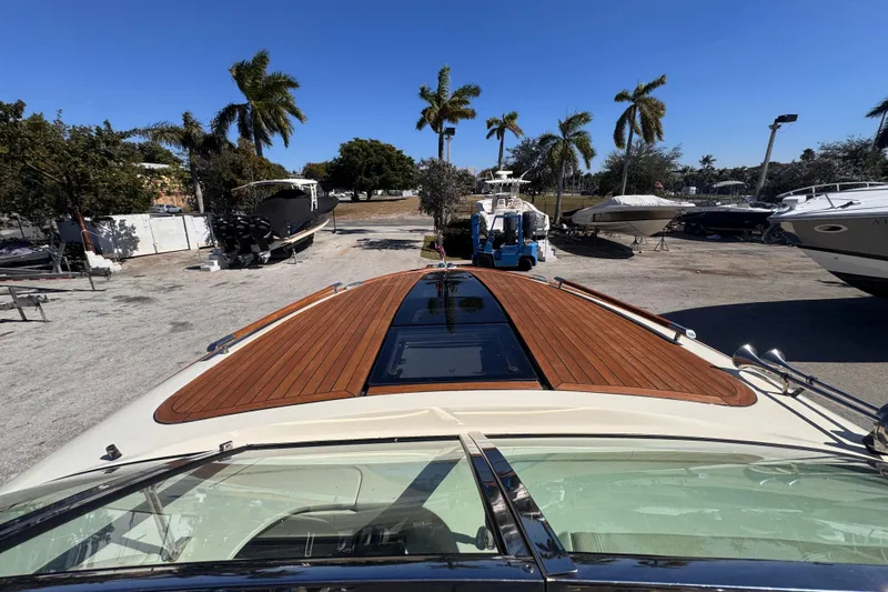 Slide: The Image of 2019 Chris-Craft Corsair 30 with teak deck, parked under clear blue sky. - 15