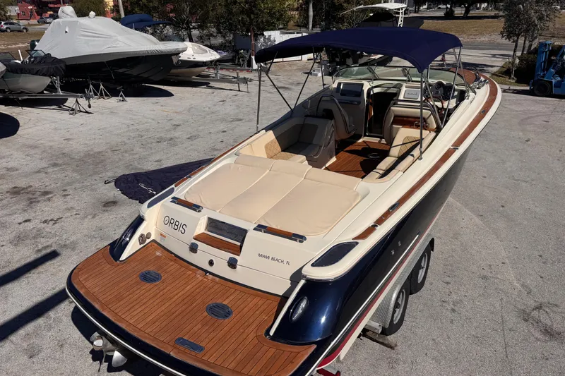 Slide: The Image of 2019 Chris-Craft Corsair 30 boat with teak deck and navy canopy, parked on trailer. - 17
