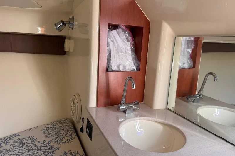 Slide: The Image of 2019 Chris-Craft Corsair 30 interior with sink, mirror, and storage compartment. - 20