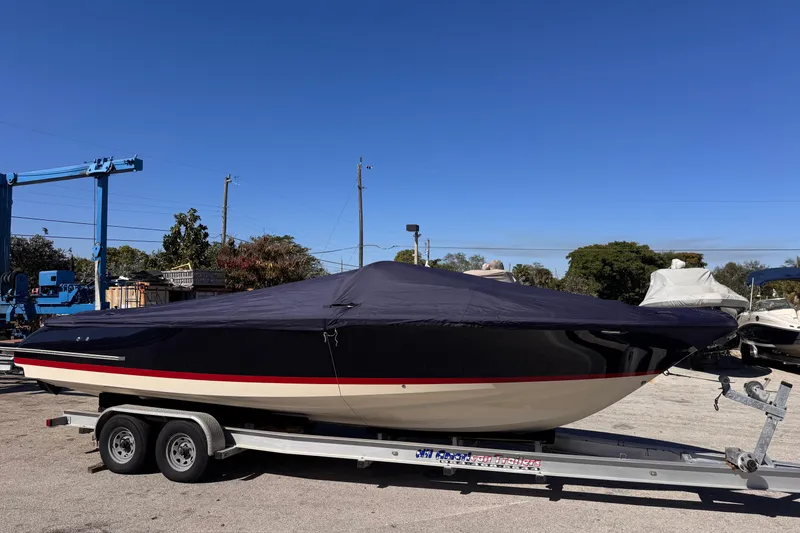 Slide: The Image of 2019 Chris-Craft Corsair 30 boat covered on a trailer under clear blue sky. - 25