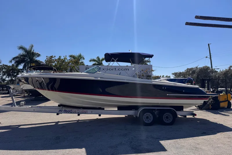 Slide: The Image of 2019 Chris-Craft Corsair 30 boat on trailer, parked outdoors under clear blue sky. - 4