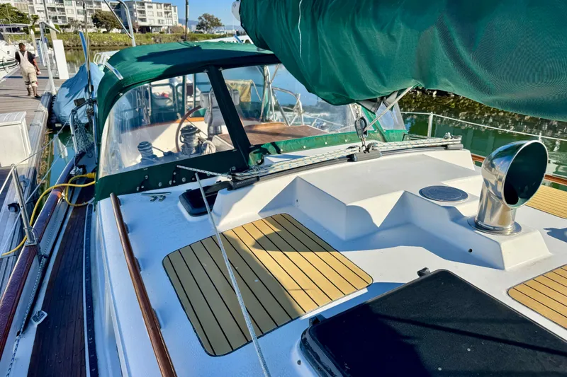 Slide: The Image of 1988 Hans Christian Christina sailboat docked, featuring green canopy and wooden deck accents. - 34