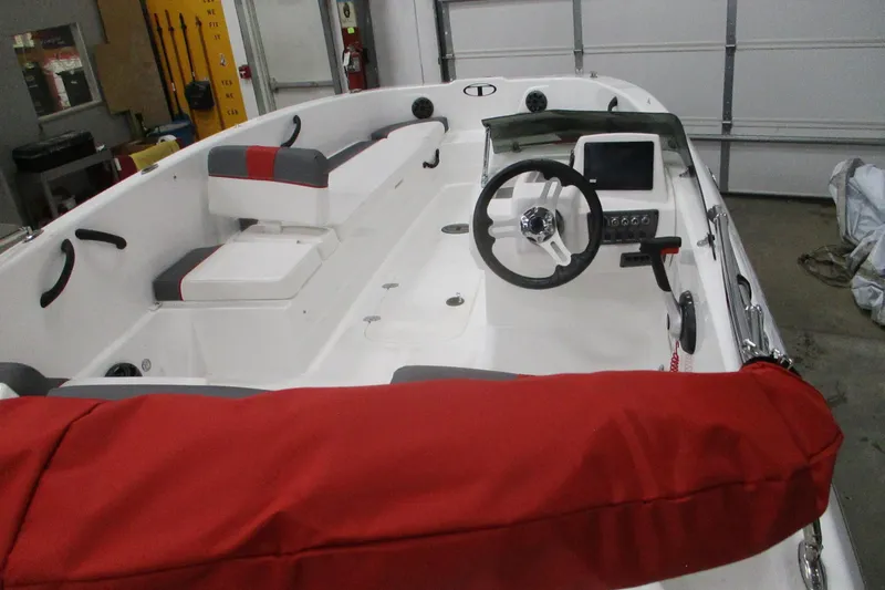 Slide: The Image of 2025 Tahoe T18 boat interior with steering wheel, red seating, and control panel. - 5