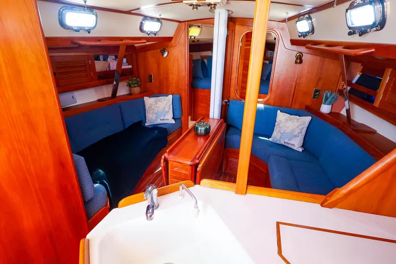 Slide: The Image of Interior of a 1999 Tartan 3500 sailboat with cozy seating and wooden finishes. - 21