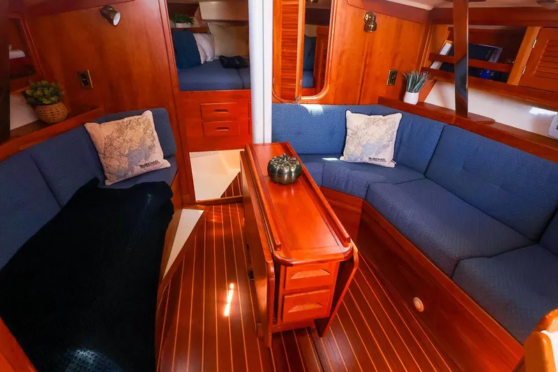 Slide: The Image of Cozy interior of 1999 Tartan 3500 sailboat with blue seating and wooden accents. - 22