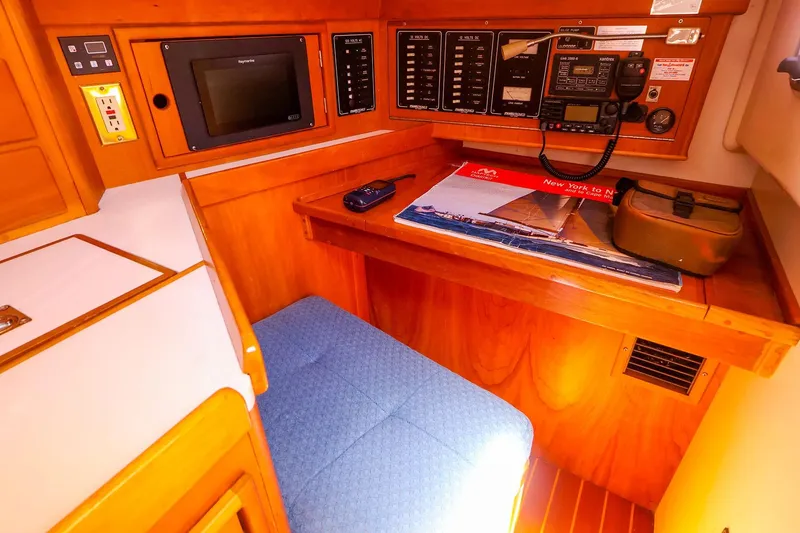 Slide: The Image of Navigation station inside a 1999 Tartan 3500 sailboat, featuring control panels and seating. - 23