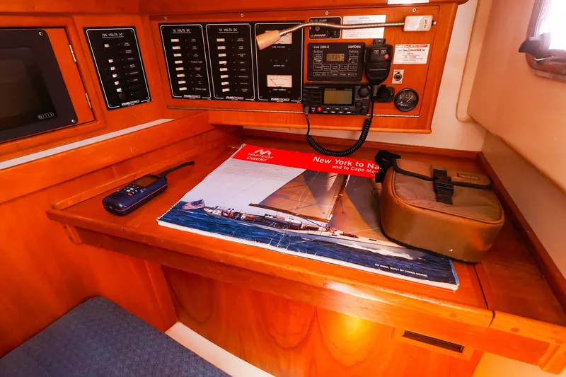 Slide: The Image of Navigation station on a 1999 Tartan 3500 sailboat with communication equipment and chart. - 24