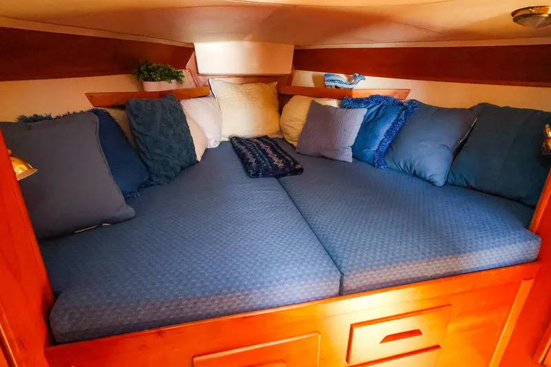 Slide: The Image of Cozy cabin interior of 1999 Tartan 3500 sailboat with blue bedding and pillows. - 27