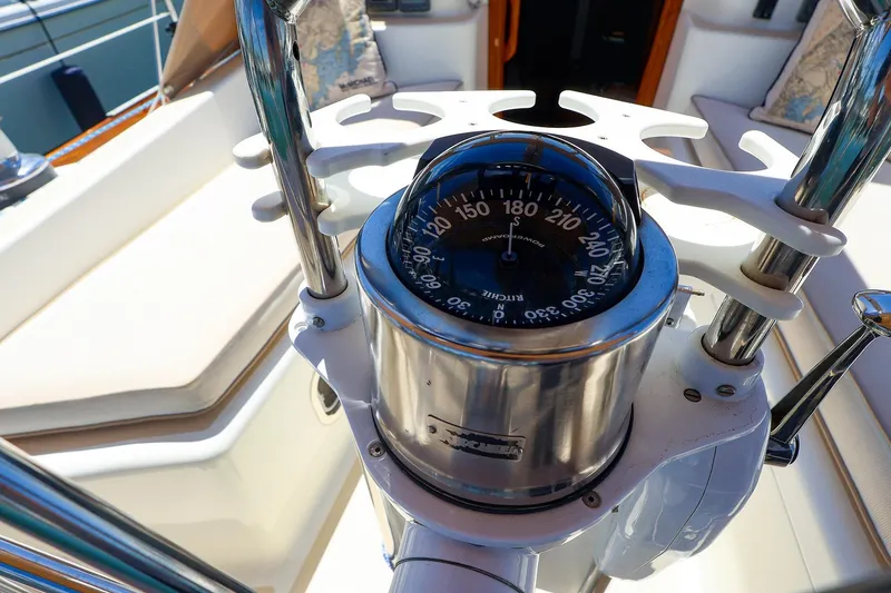 Slide: The Image of Compass on a 1999 Tartan 3500 sailboat, surrounded by polished metal and seating. - 3