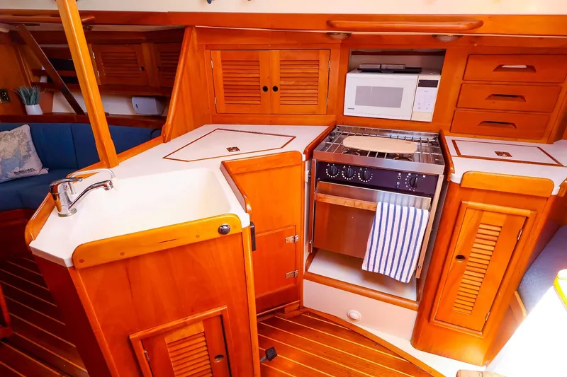 Slide: The Image of 1999 Tartan 3500 yacht interior kitchen with wooden cabinetry and modern appliances. - 32