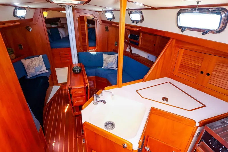 Slide: The Image of Interior of a 1999 Tartan 3500 sailboat with wood finish and cozy seating area. - 34