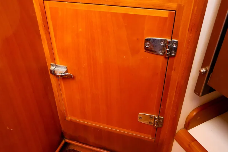 Slide: The Image of Wooden cabinet door with metal hinges and latch on a 1999 Tartan 3500 yacht. - 36