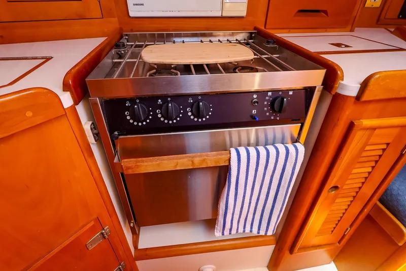 Slide: The Image of Wooden yacht kitchen with stainless steel stove, striped towel, and cutting board, Tartan 3500, 1999. - 39