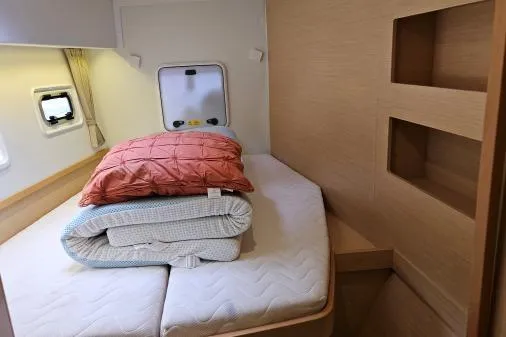 Slide: The Image of 2017 Lagoon 42 yacht cabin with cozy bed, pillows, and natural wood accents. - 14