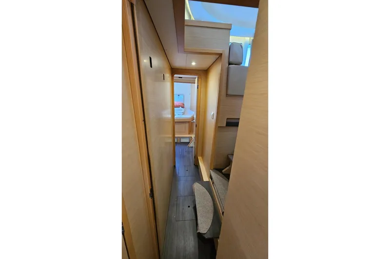 Slide: The Image of Interior hallway of 2017 Lagoon 42 catamaran, featuring modern wood paneling and cozy cabin access. - 15