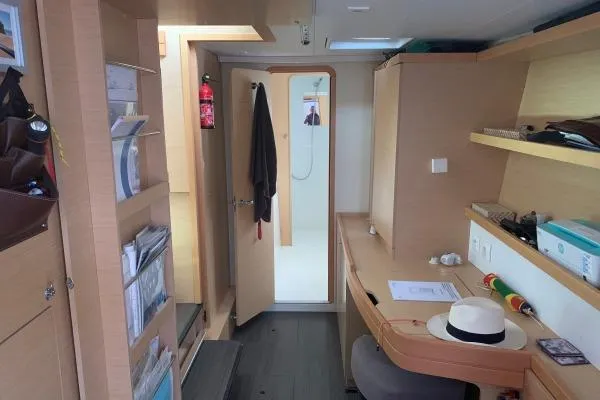 Slide: The Image of Interior of 2017 Lagoon 42 catamaran with desk, shelves, and open door to bathroom. - 19