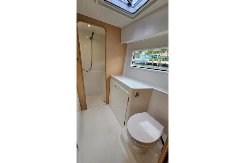 Slide: The Image of Bathroom interior of 2017 Lagoon 42 yacht, featuring shower, toilet, and window view. - 25