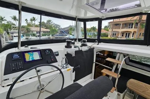 Slide: The Image of Cockpit of 2017 Lagoon 42 catamaran with navigation equipment and marina view. - 35