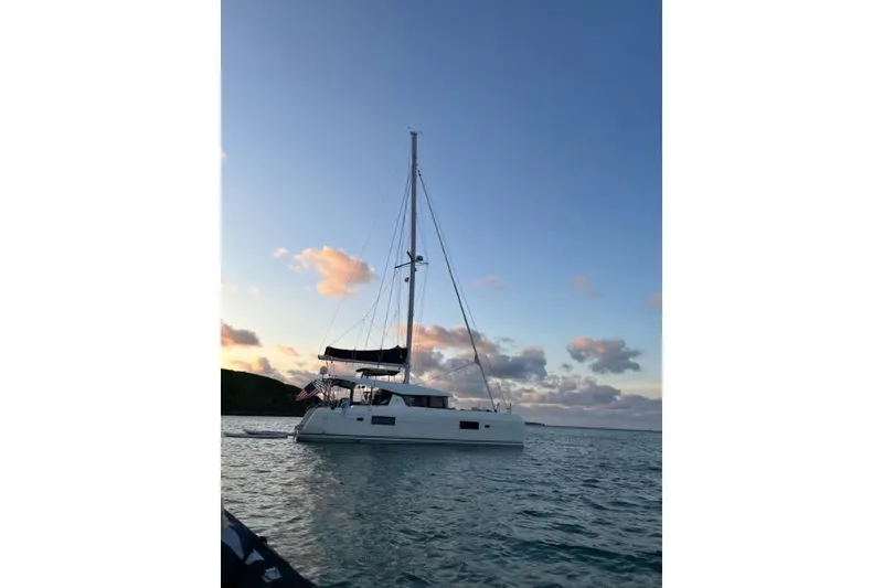 Slide: The Image of 2017 Lagoon 42 catamaran sailing at sunset with calm waters and scenic sky. - 4