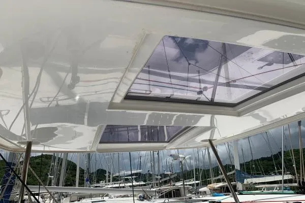 Slide: The Image of 2017 Lagoon 42 catamaran with skylights, docked at a marina. - 40