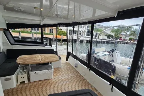 Slide: The Image of 2017 Lagoon 42 catamaran interior with seating, table, and marina view. - 46