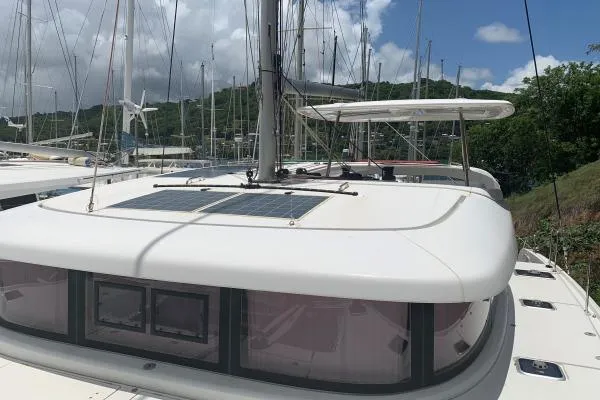Slide: The Image of 2017 Lagoon 42 catamaran with solar panels, docked in a marina. - 63