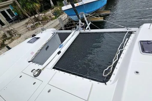 Slide: The Image of 2017 Lagoon 42 catamaran with netted deck, docked by waterfront. - 67