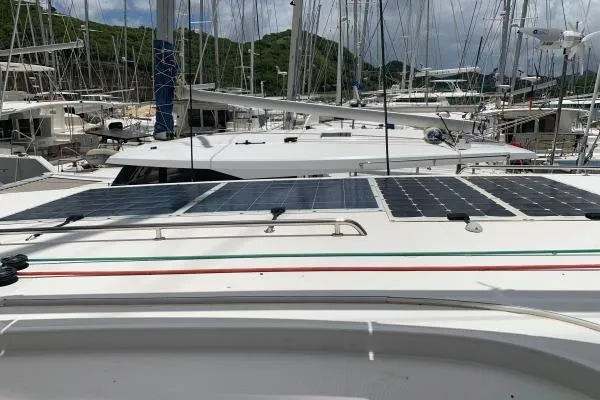 Slide: The Image of 2017 Lagoon 42 catamaran with solar panels docked in a marina. - 71