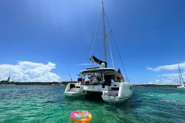 Slide: The Image of 2017 Lagoon 42 catamaran anchored in clear turquoise waters under a bright blue sky. - 74