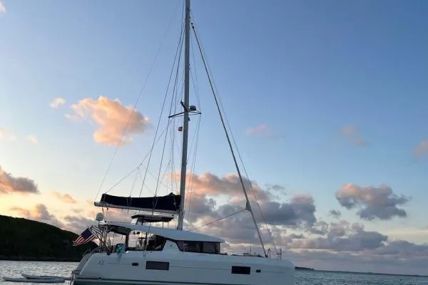 Slide: The Image of 2017 Lagoon 42 catamaran sailing at sunset with scenic ocean backdrop. - 76