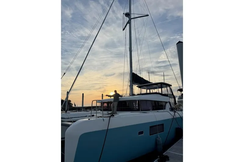 Slide: The Image of 2017 Lagoon 42 catamaran docked at sunset with a person on deck. - 80