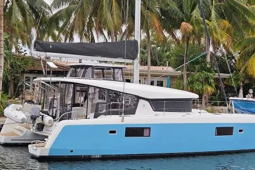 Slide: The Image of 2017 Lagoon 42 catamaran docked near tropical palm trees. - 81