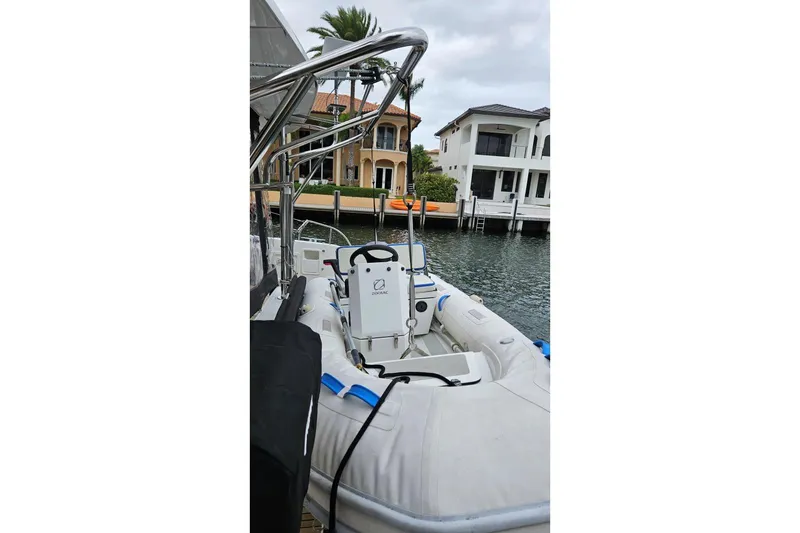 Slide: The Image of 2017 Lagoon 42 catamaran docked in a marina with a small inflatable boat. - 84