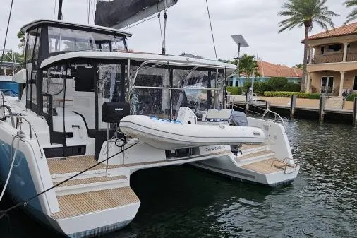 Slide: The Image of 2017 Lagoon 42 yacht with attached inflatable dinghy and outboard motor. - 85