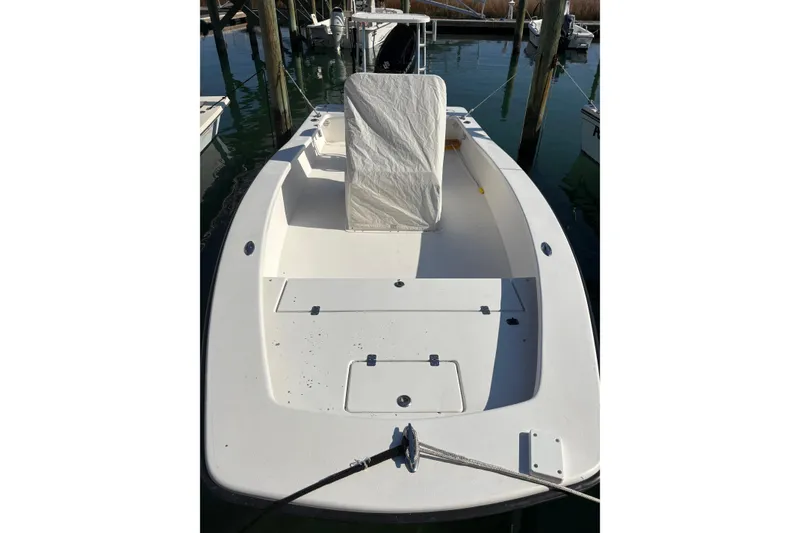 Slide: The Image of 2007 Intruder 198 boat docked, featuring a spacious deck and covered seating. - 10