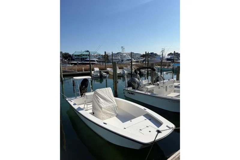 Slide: The Image of 2007 Intruder 198 boat docked in a marina under clear blue skies. - 2