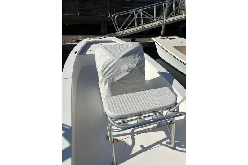 Slide: The Image of 2007 Intruder 198 boat interior with covered seat and docked setting. - 5