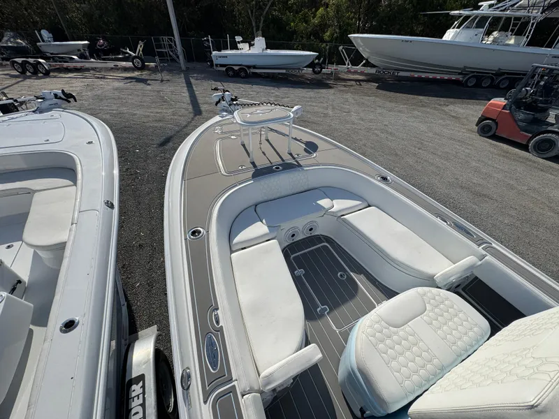 Slide: The Image of 2024 Contender 26 Bay boat with sleek design and spacious seating, parked outdoors. - 12