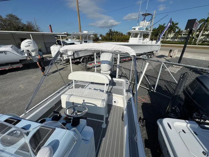 Slide: The Image of 2024 Contender 26 Bay boat with sleek design, parked outdoors under clear sky. - 13
