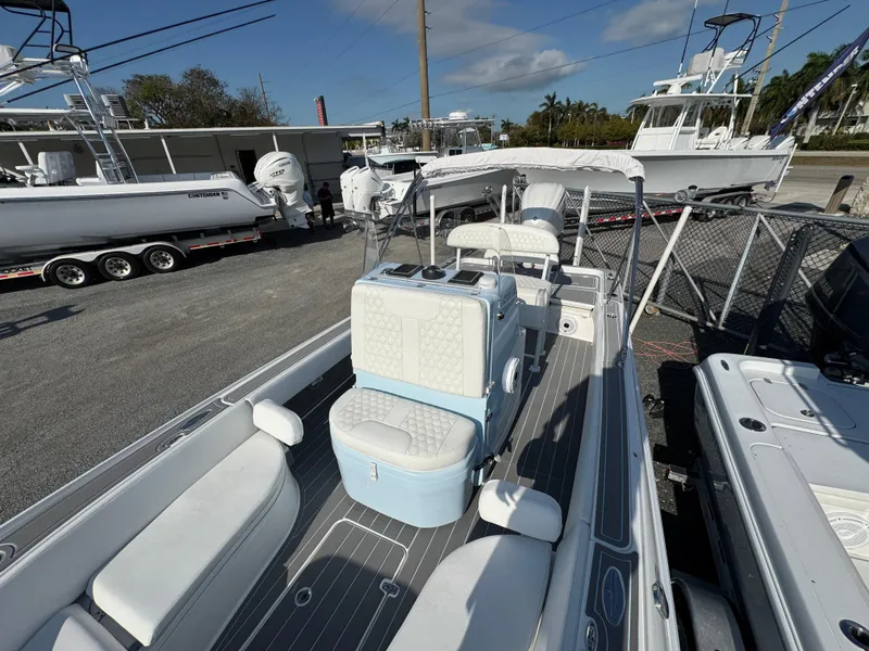 Slide: The Image of 2024 Contender 26 Bay boat with sleek interior and seating, docked at a marina. - 17