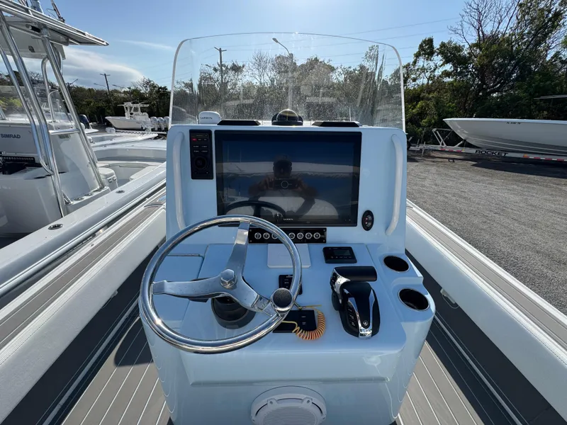 Slide: The Image of 2024 Contender 26 Bay boat console with steering wheel and navigation display. - 22
