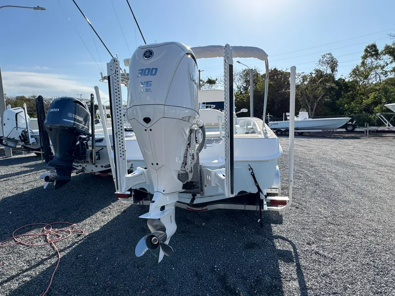 Slide: The Image of 2024 Contender 26 Bay boat with Yamaha 300 V6 engine, parked on gravel. - 5