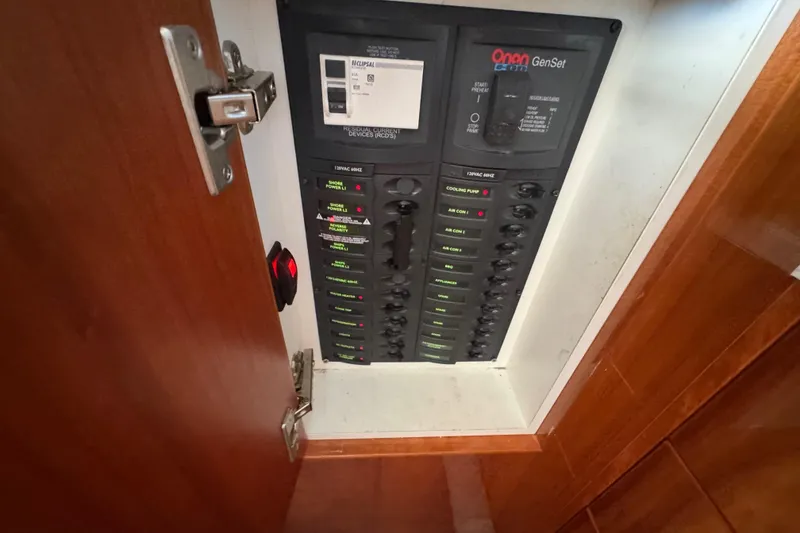 Slide: The Image of Electrical panel inside 2016 Riviera 43 Open Flybridge yacht, featuring Onan GenSet controls. - 11