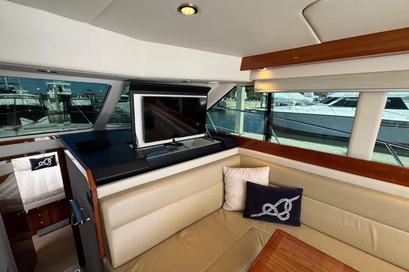 Slide: The Image of Interior of 2016 Riviera 43 Open Flybridge yacht with seating and TV, docked at marina. - 13