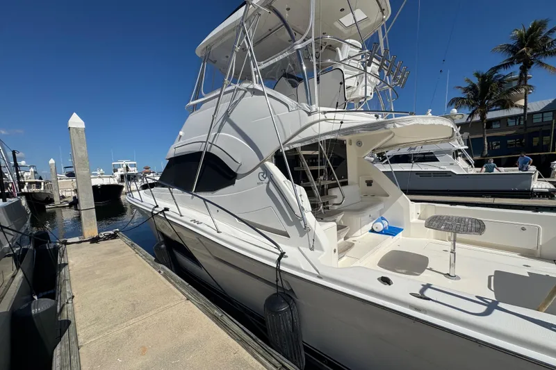 Slide: The Image of 2016 Riviera 43 Open Flybridge yacht docked at marina under clear blue sky. - 4